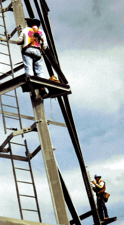 3 Tower construction crew torquing bolts at the base of the lattice tower