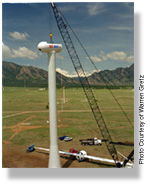 Wind turbine nacelle being placed on top of a tower